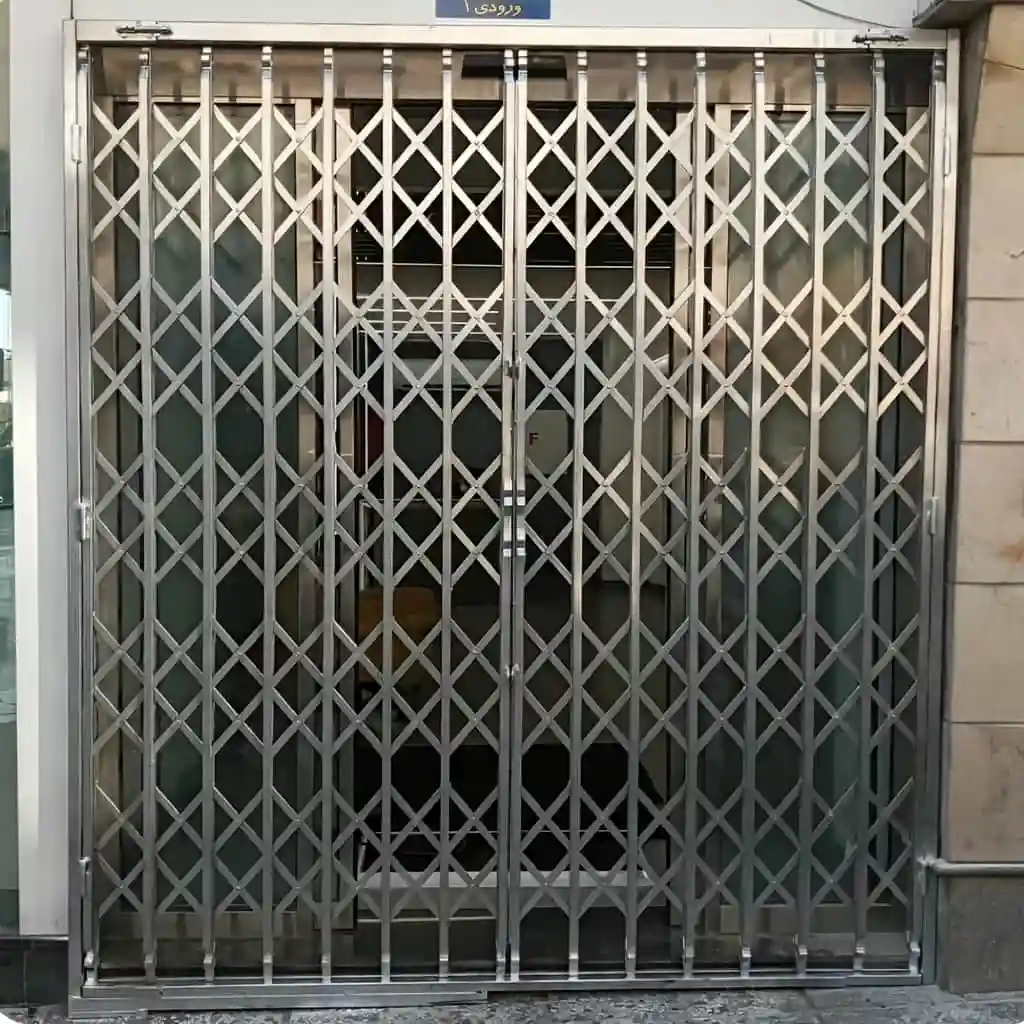 تصویر حفاظ آکاردئونی تمام گل دوبل سه جداره تسمه ۲.۵ سانتی متر روی درب ورودی