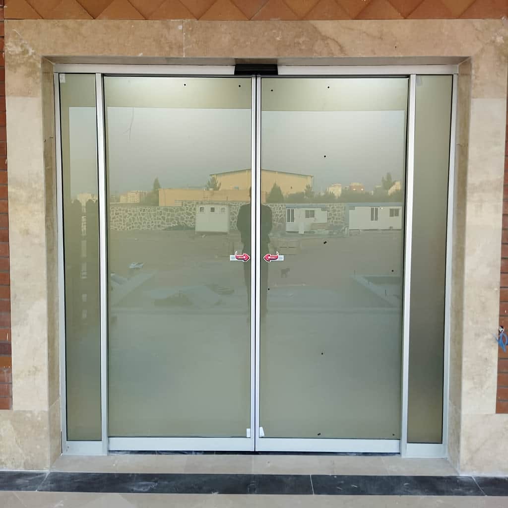 اجرای درب شیشه ای کشویی دوطرفه برای دهانه عریض فروشگاه