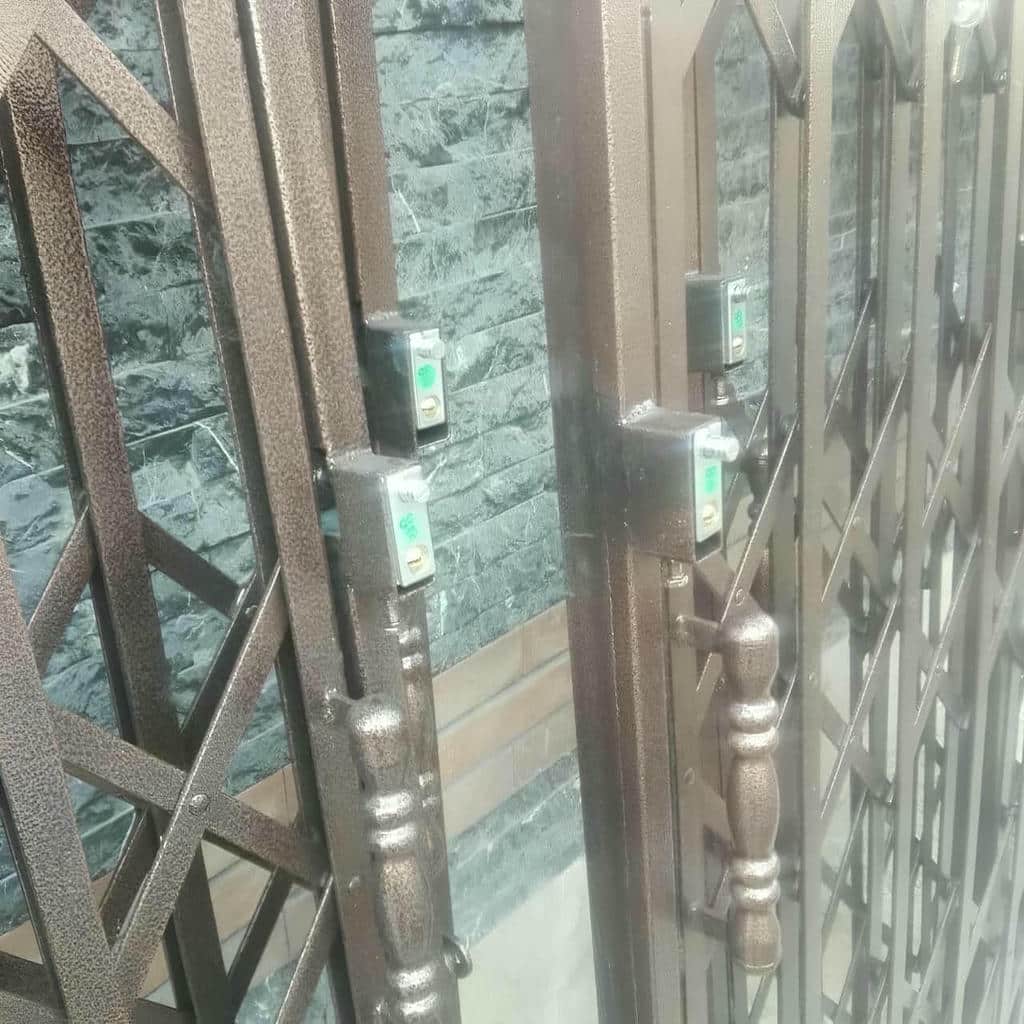 حفاظ درب آکاردئونی خاکستری در راهروی نیمه‌باز استان زنجان