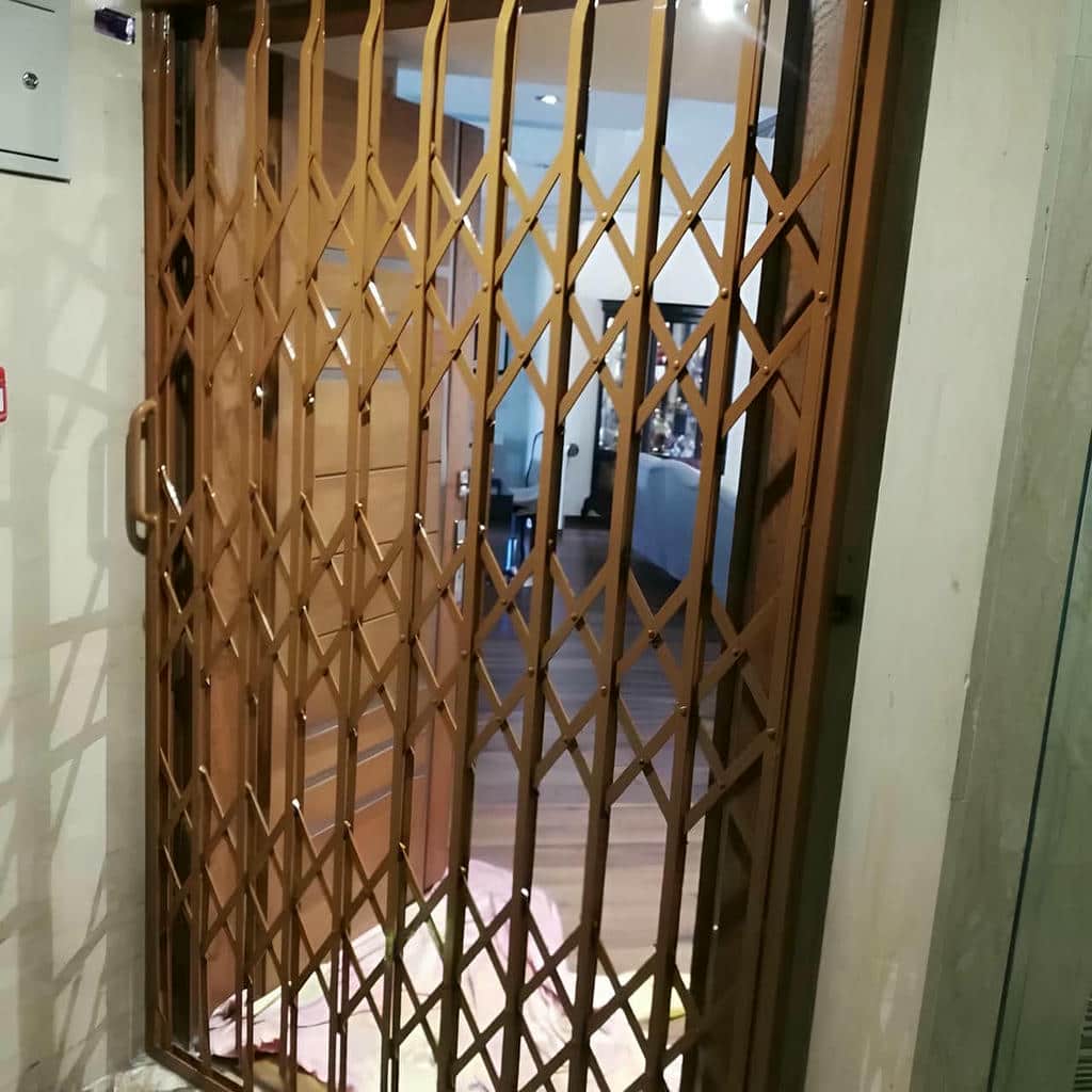 حفاظ درب آکاردئونی خاکستری کنار لابی شیشهای حفاظ درب آکاردئونی خاکستری کنار لابی شیشهای