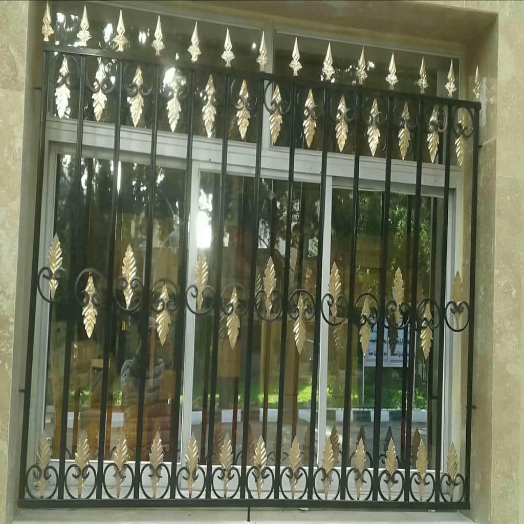 حفاظ پنجره مشکی روی نمای آجری خانه قدیمی ایلام