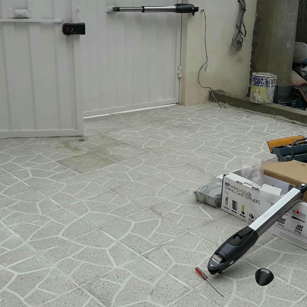 دربازکن اتوماتیک سفید کنار چارچوب آجری حیاط مشهد