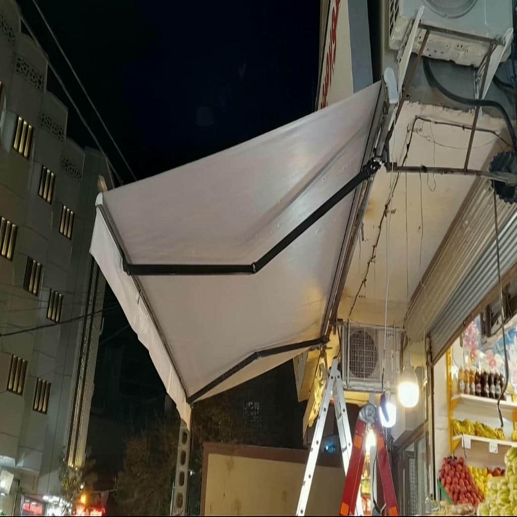 سایبان برقی جمع شده زیر پیشانی مینیمال ساختمان