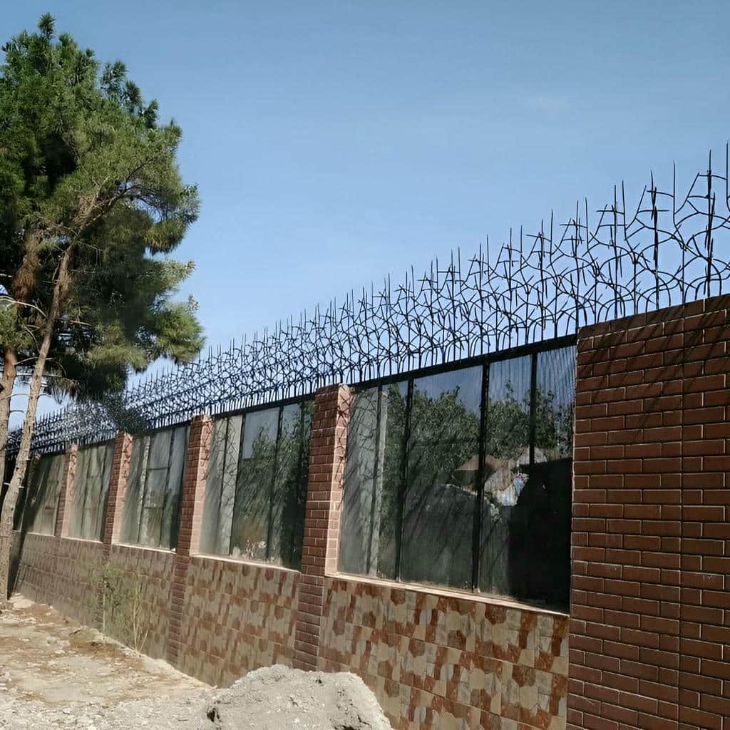 نرده فرسوده زنگ زده روی کلاهک ترک خورده حیاط