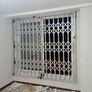 حفاظ درب آکاردئونی خاکستری در راهروی نیمه‌باز استان هرمزگان