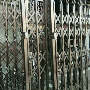 حفاظ درب آکاردئونی مشکی کنار سنگ تراورتن تبریز