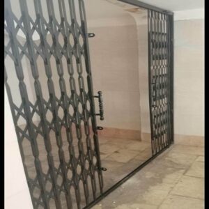 حفاظ درب آکاردئونی مشکی کنار ورودی مجتمع استان آذربایجان شرقی