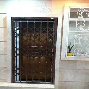 حفاظ درب آکاردئونی مشکی کنار پارکینگ ساختمان استان بوشهر