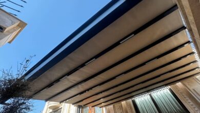 سایبان برقی کرم روی ایوان سنگفرش باغ ویلای سنندج
